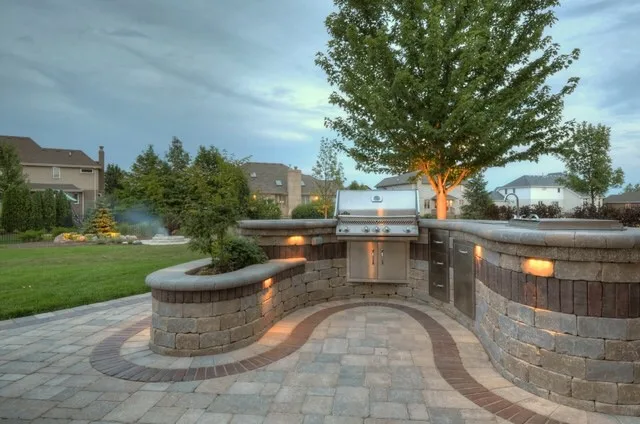 Tree uplighting and retaining wall accent lights in suburban backyard — landscape lighting by Landforms Design Inc Cedar Rapids Iowa