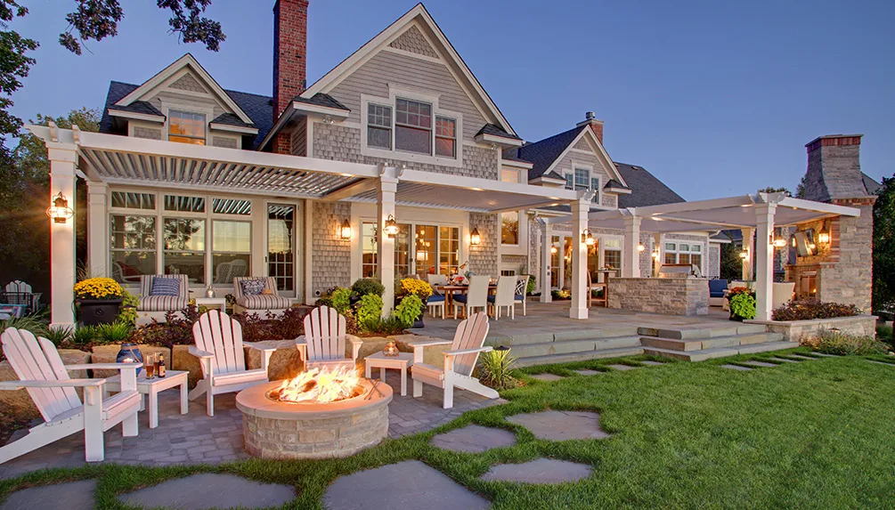 Backyard patio with warm landscape lighting at dusk — outdoor lighting installation by Landforms Design Inc, Cedar Rapids Iowa