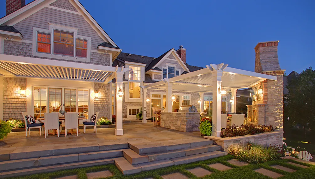 Pergola and outdoor kitchen patio lighting design at dusk — landscape lighting by Landforms Design Inc Cedar Rapids Iowa
