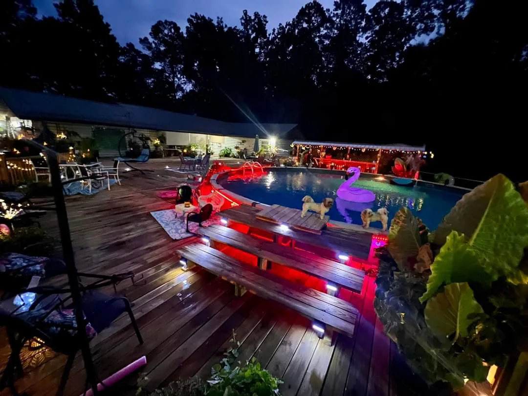 Backyard deck and pool surround lighting at night — outdoor landscape lighting by Landforms Design Inc Cedar Rapids Iowa 2023