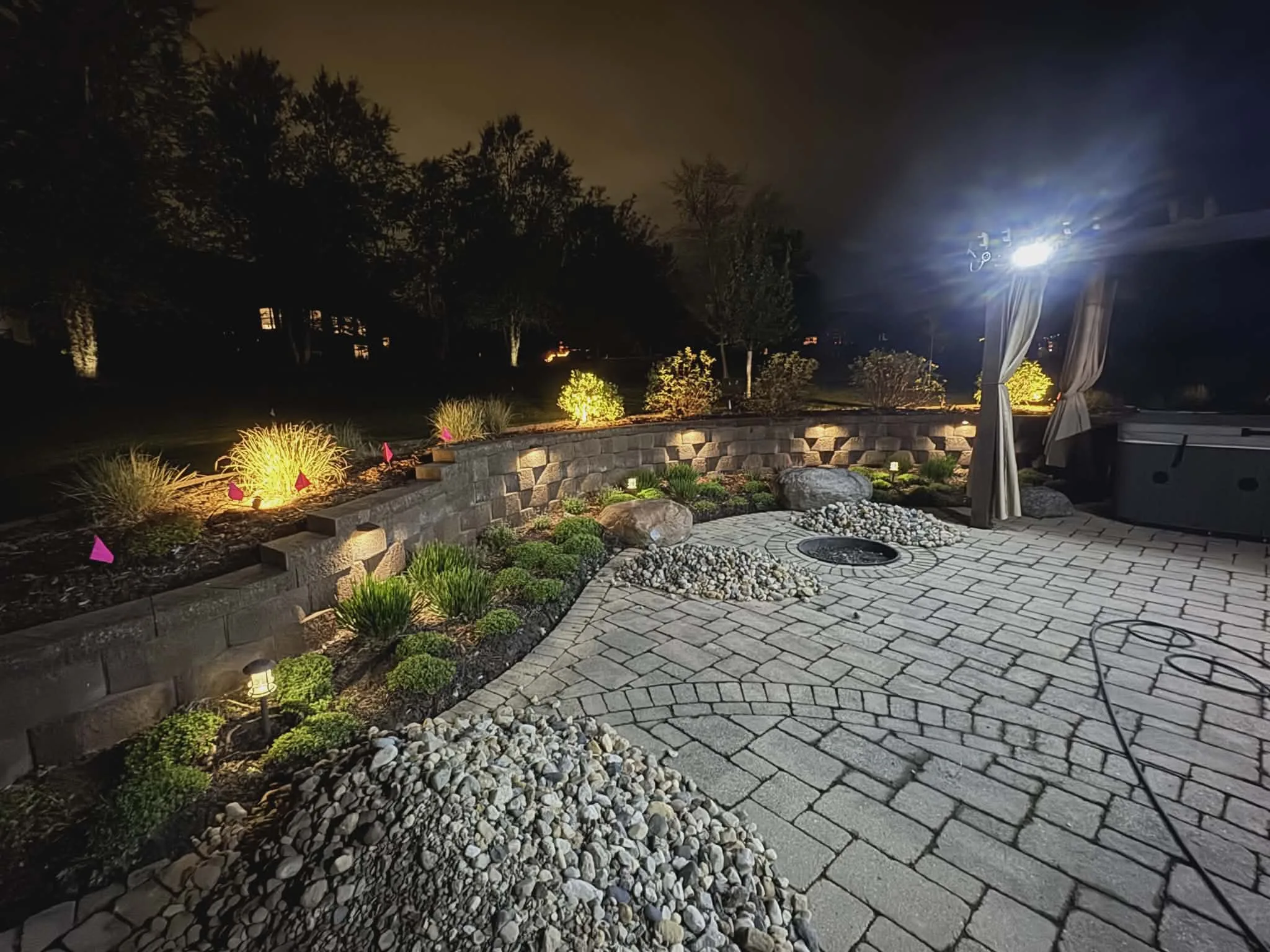 Patio path lighting and outdoor living area illumination at night — landscape lighting by Landforms Design Inc Cedar Rapids Iowa 2026