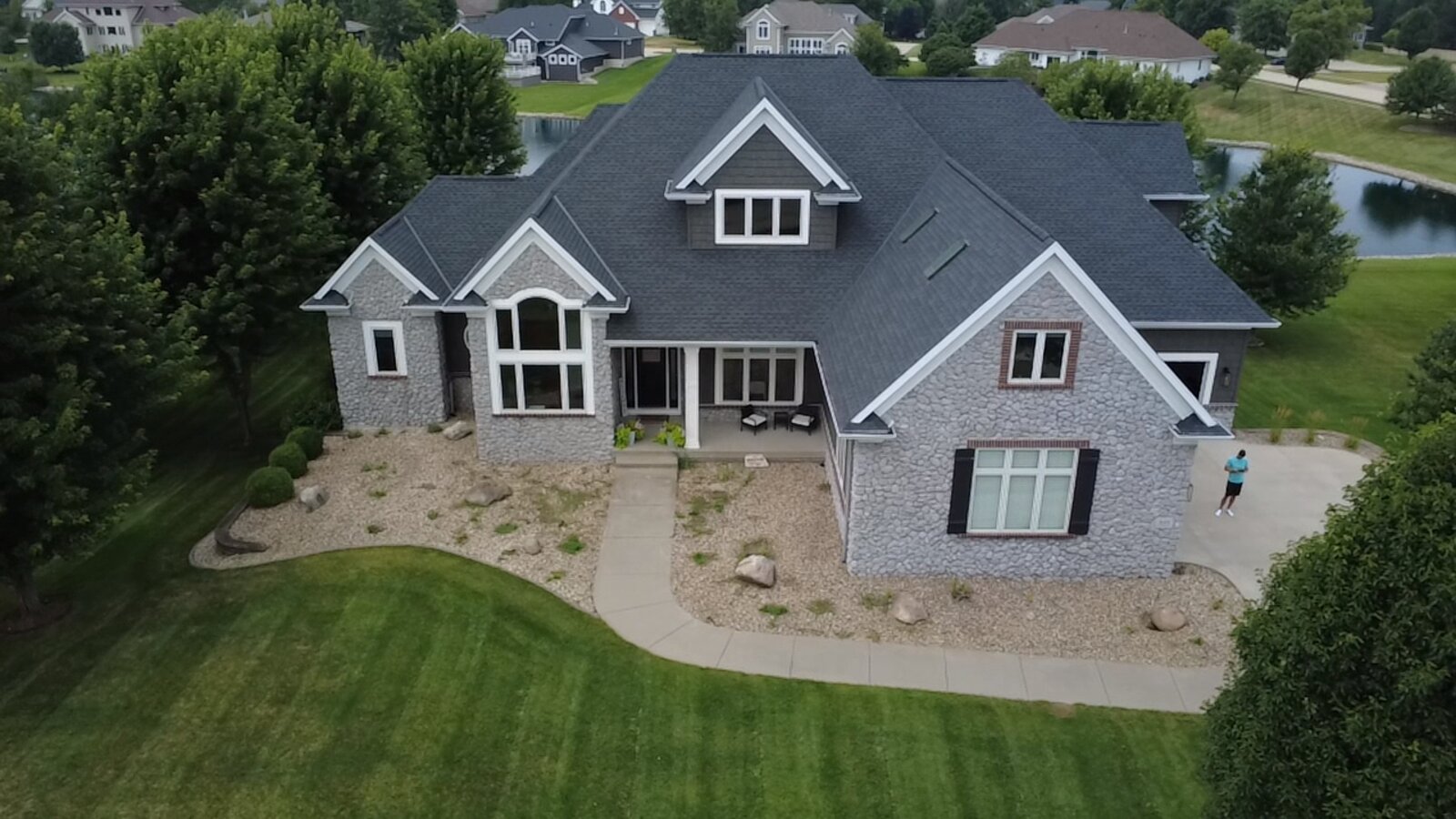 Robins Iowa front yard before landscape design — aerial view of newly renovated home exterior with bare lawn, no plantings, no walkway definition, no landscape lighting