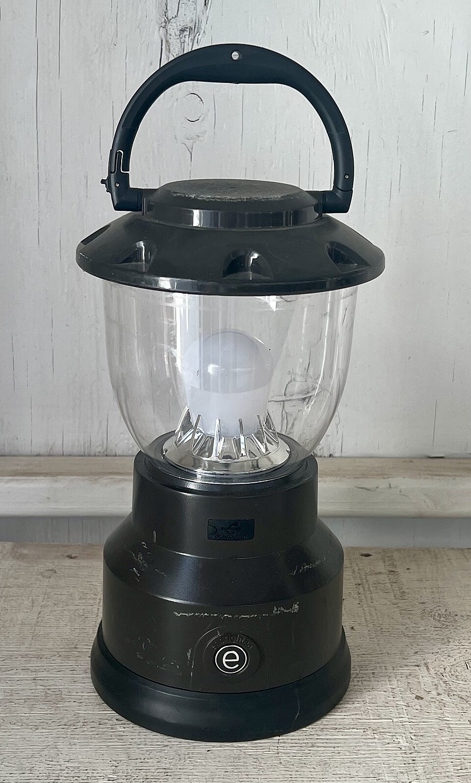 A black LED camping lantern with a clear globe and a top carry handle