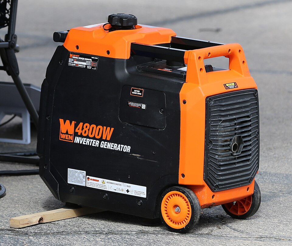 An orange and black WEN 4800 inverter generator with wheels, sitting on pavement